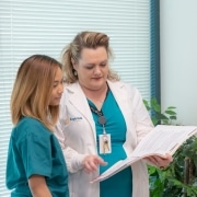 Nurse instructor showing student inside of a file