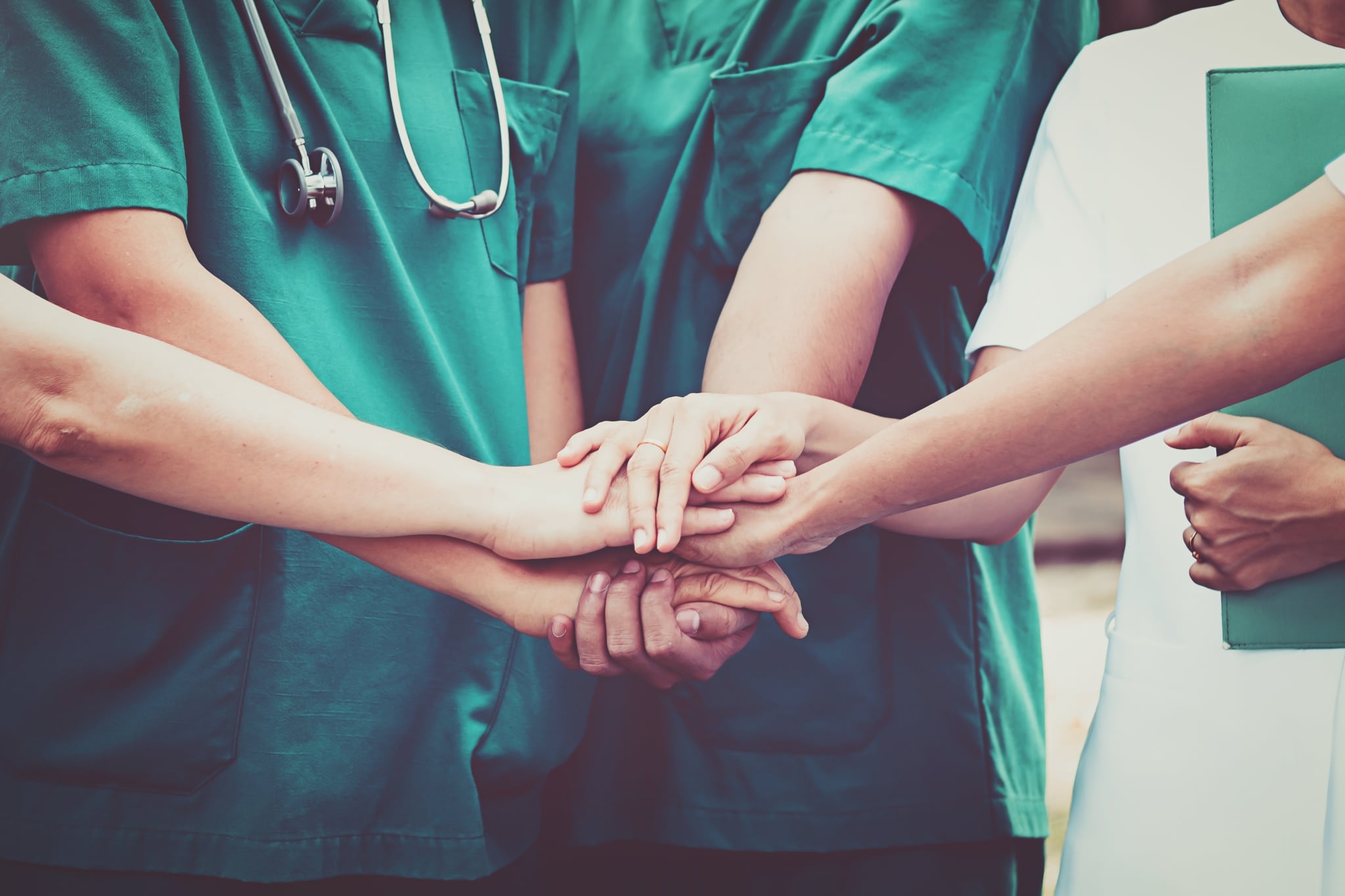 Healthcare workers touching hands as a sign of teamwork