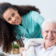 Smiling female caregiver with elderly man