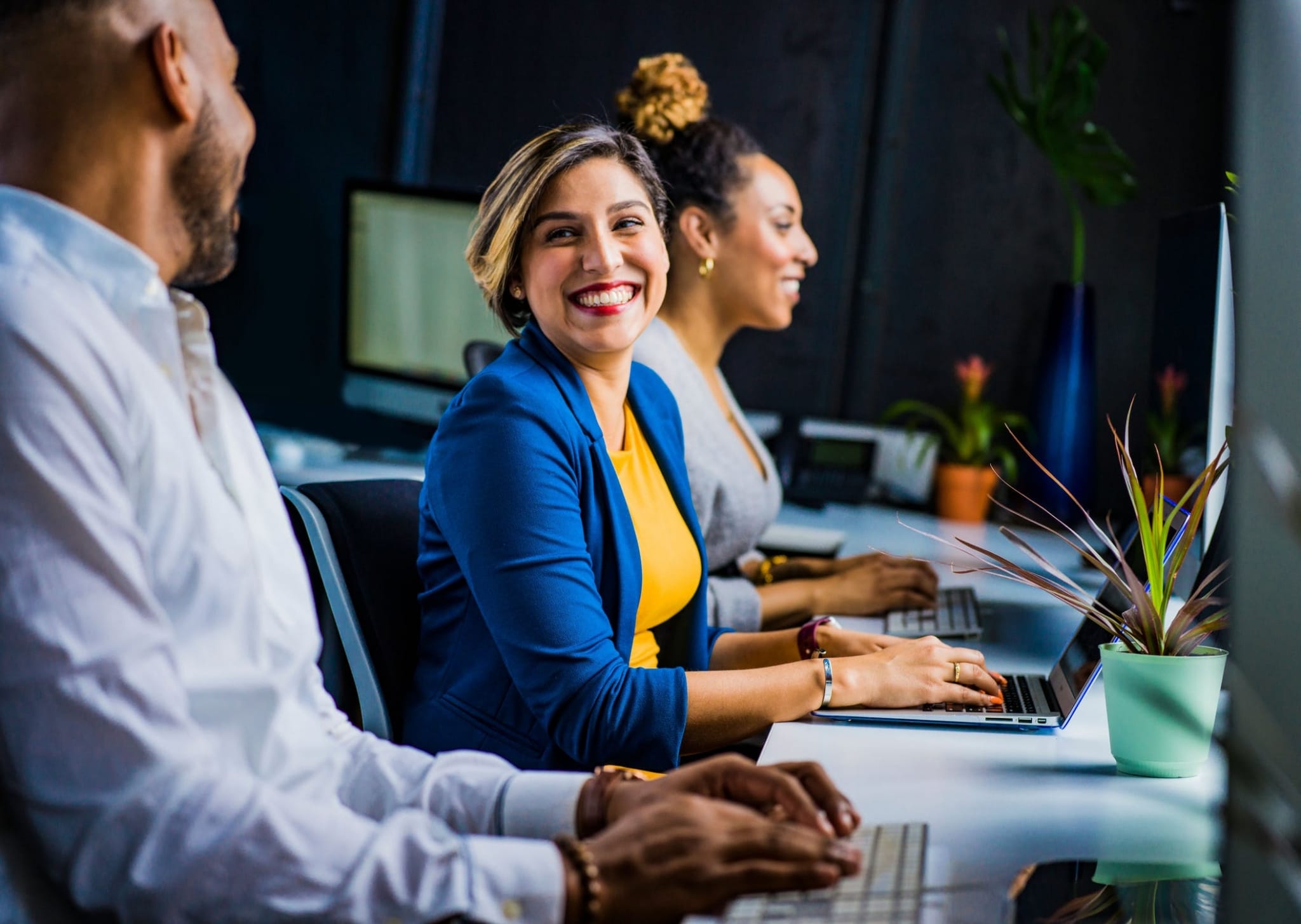 Smiling professionals on laptops