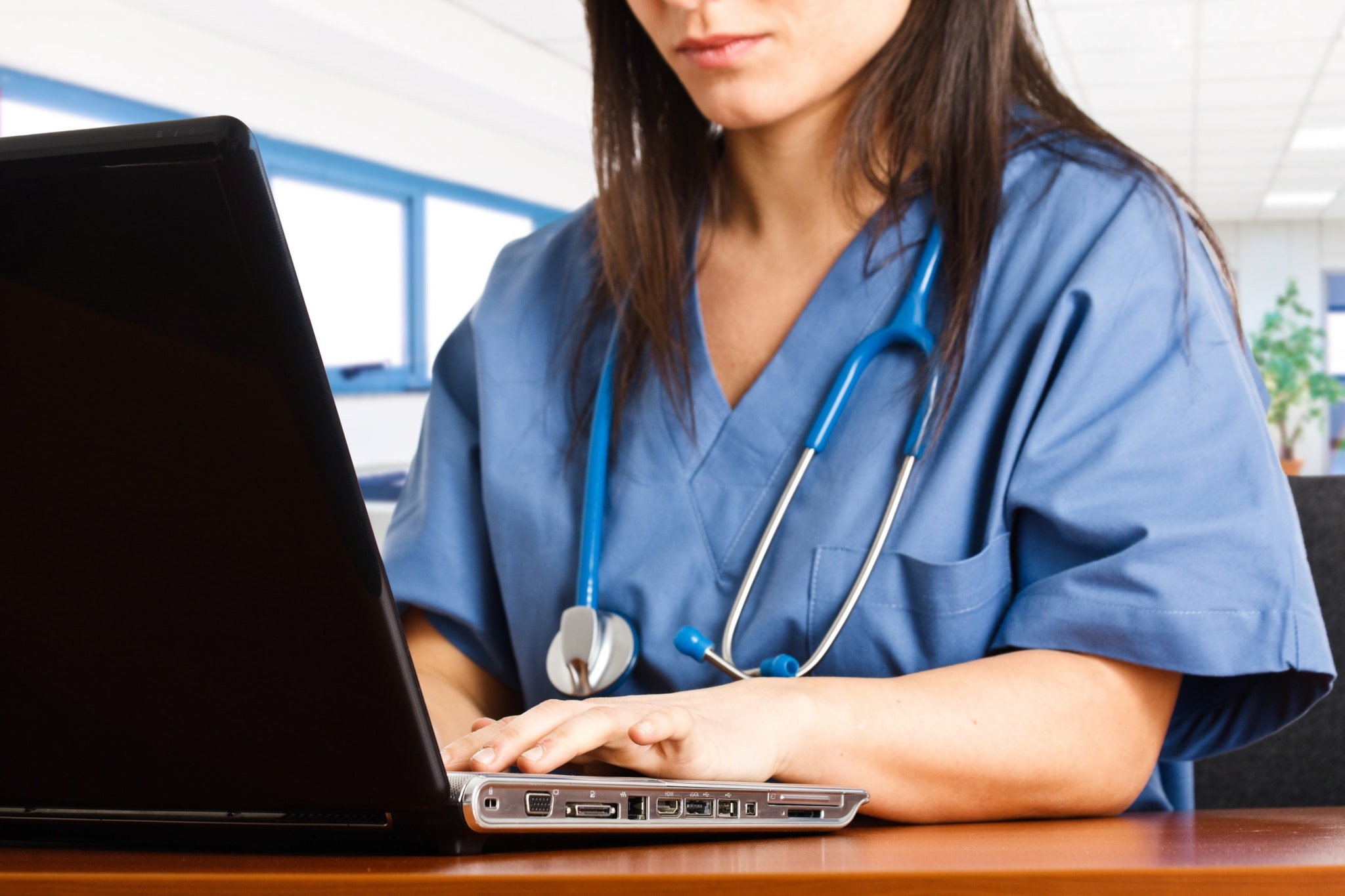 Nurse typing on a laptop