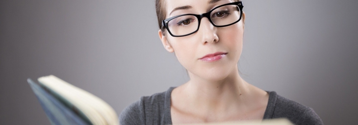 Woman with glasses reading a book