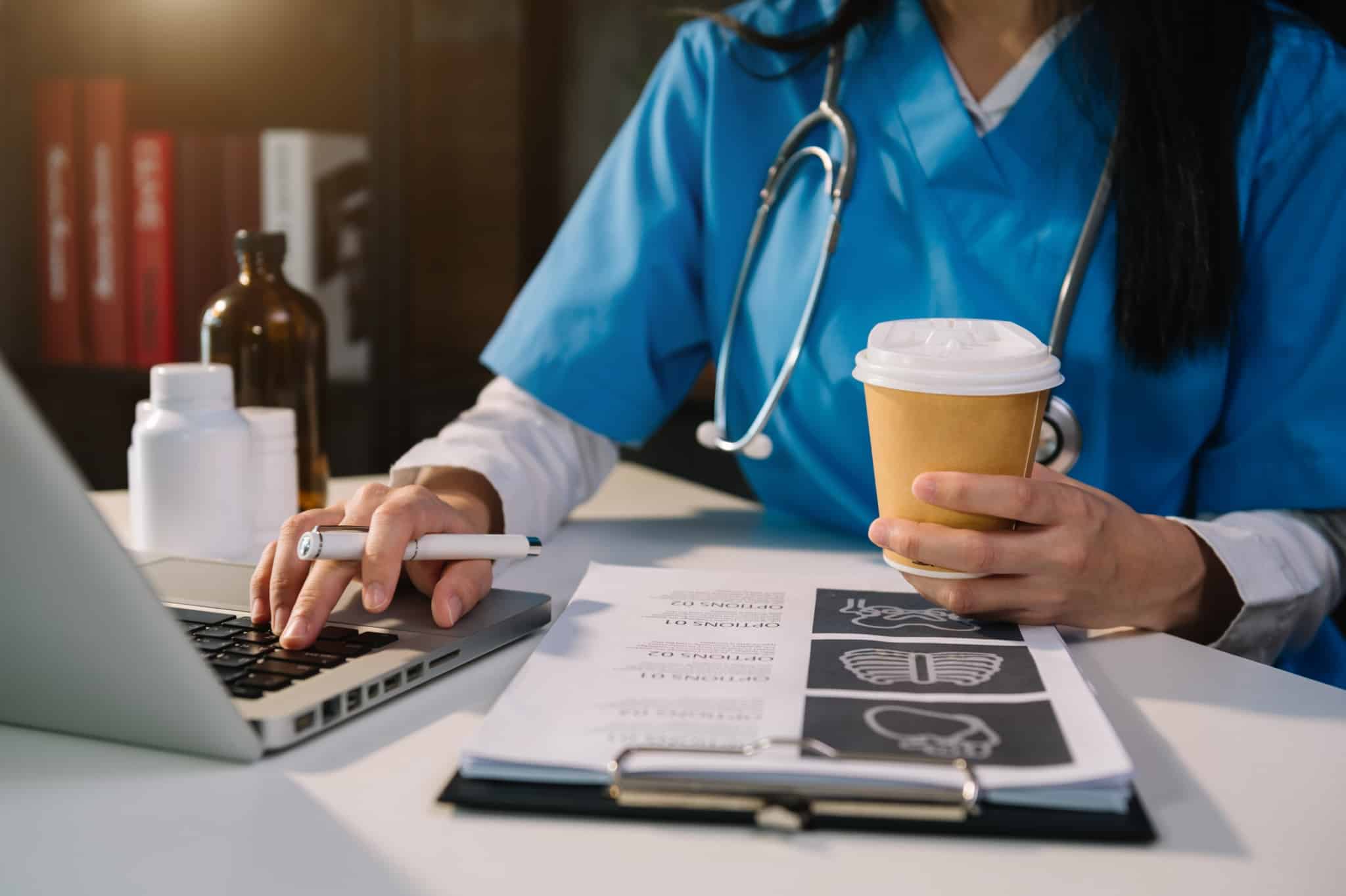 Medical professional typing on a laptop