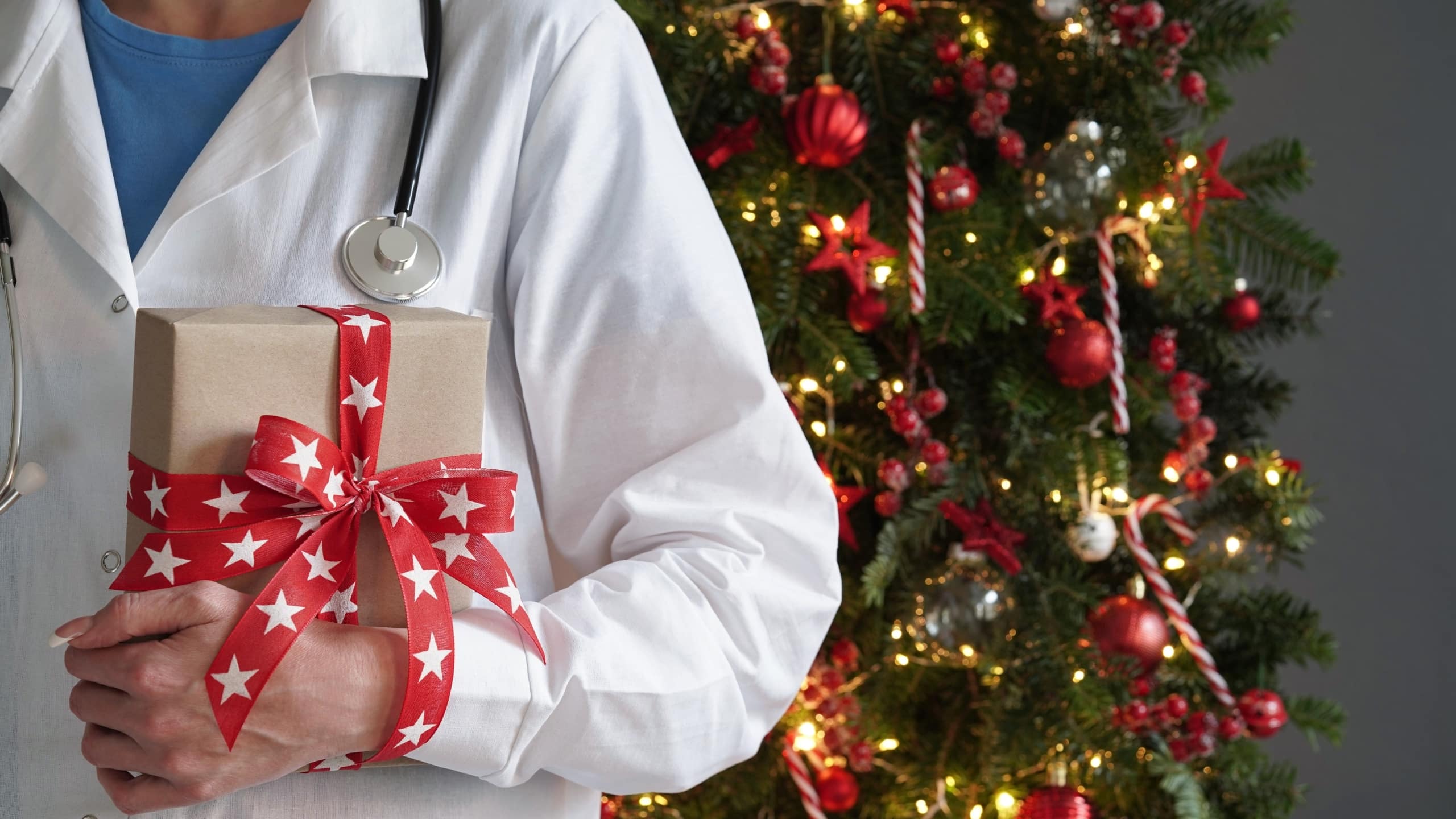 Close up of a medical professional by a Christmas tree