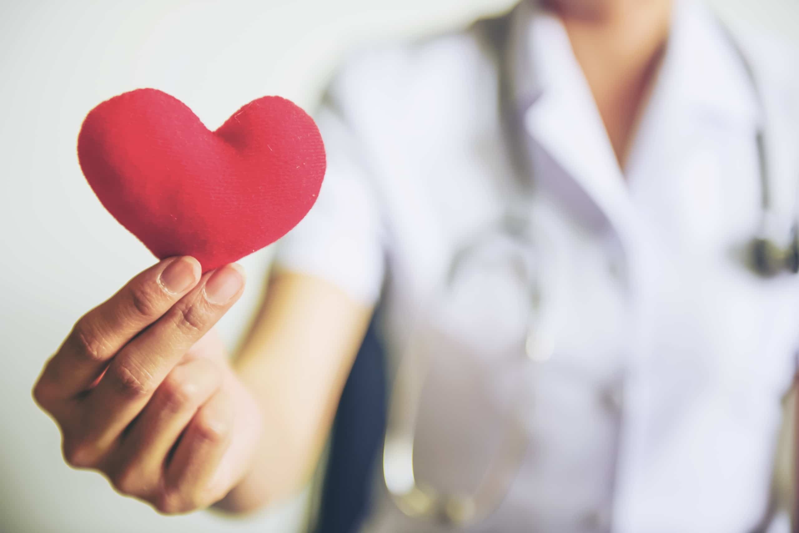 Nurse holding up a heart plushie