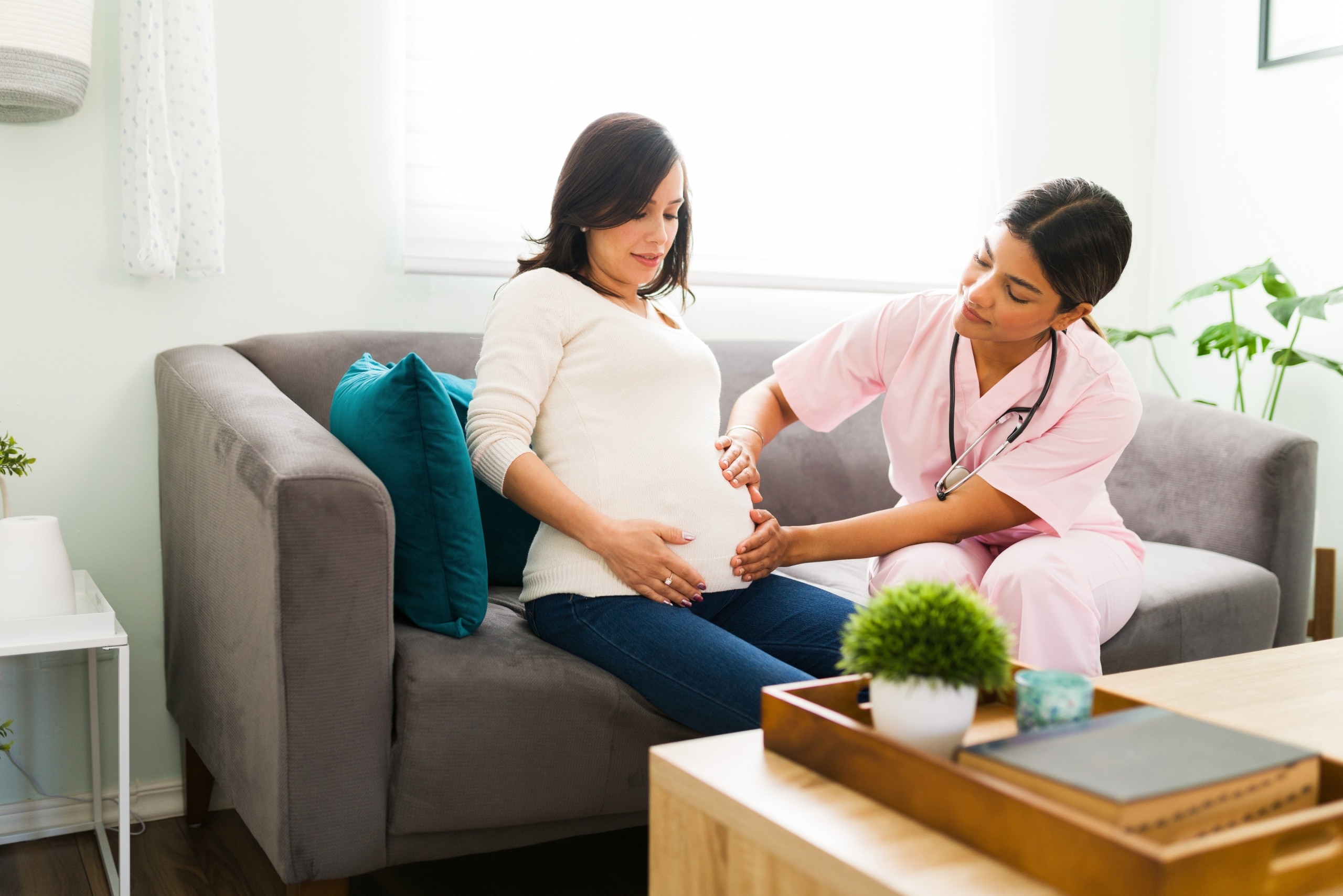 Midwife with a pregnant patient on a couch