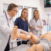 Two students working with an instructor in the simulation lab