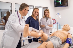 Two students working with an instructor in the simulation lab