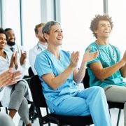 Group of medical professionals clapping while seated