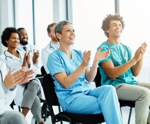 Group of medical professionals clapping while seated