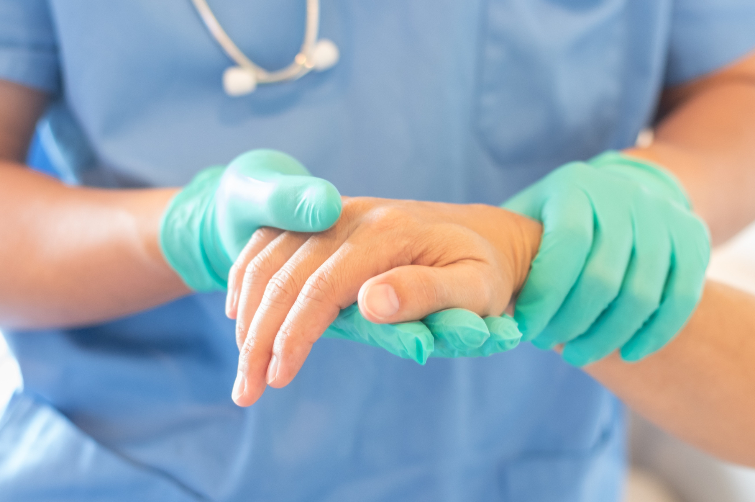 Close up of a nurse holding a patient's hand