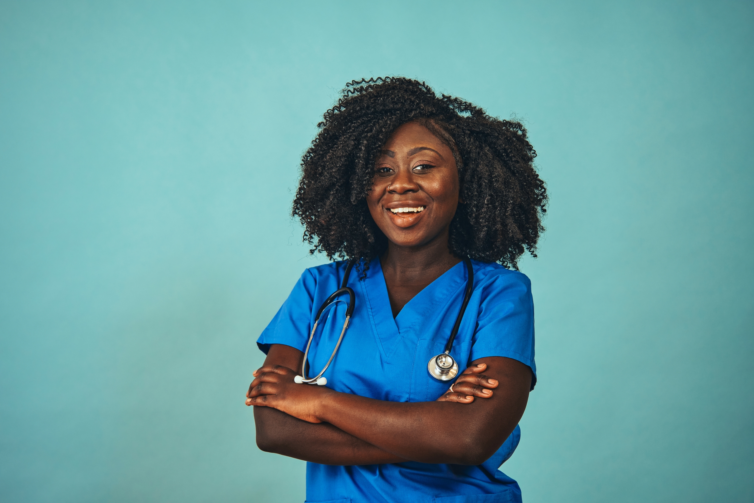 Smiling African-American medical professional against a teal backdrop