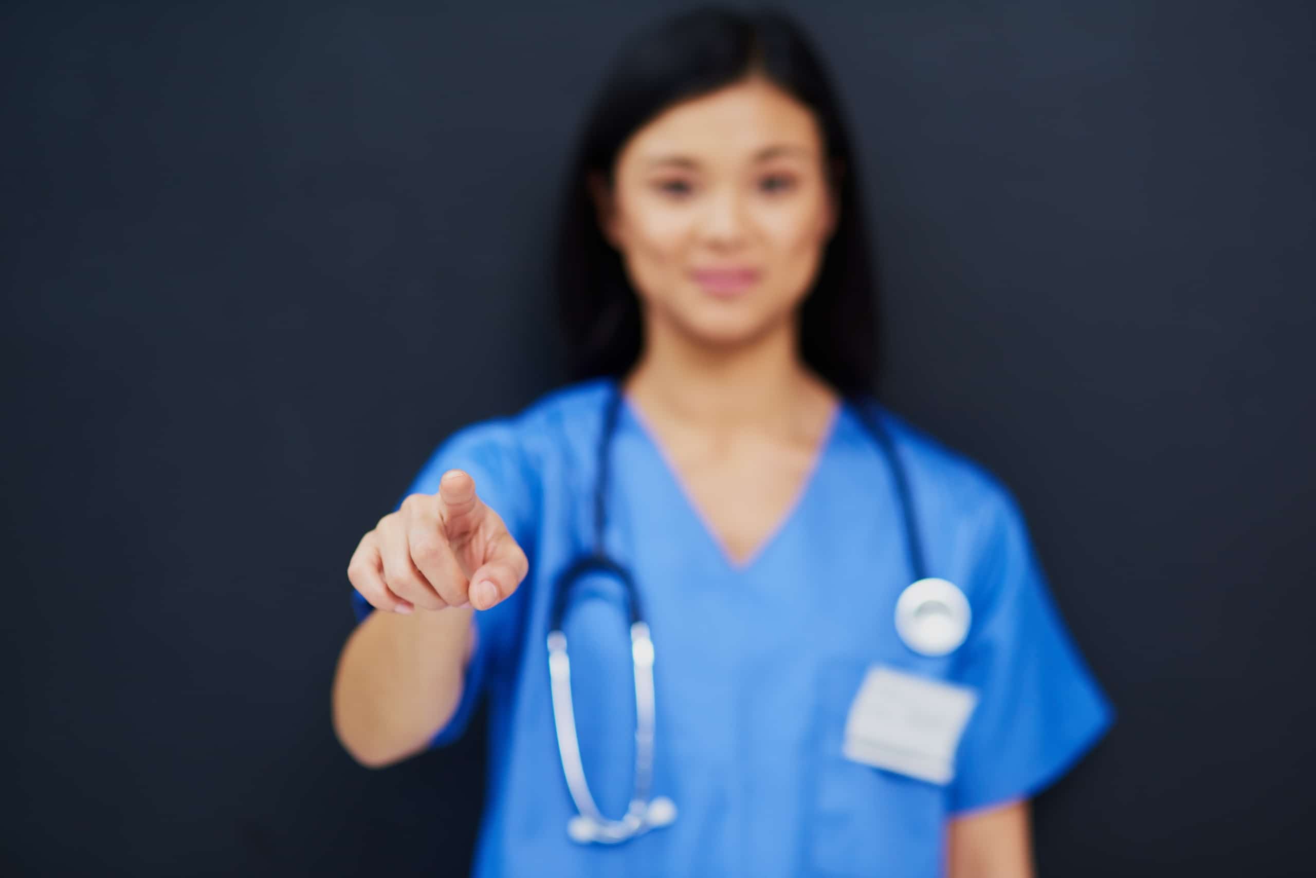 Blurred nurse pointing toward the camera
