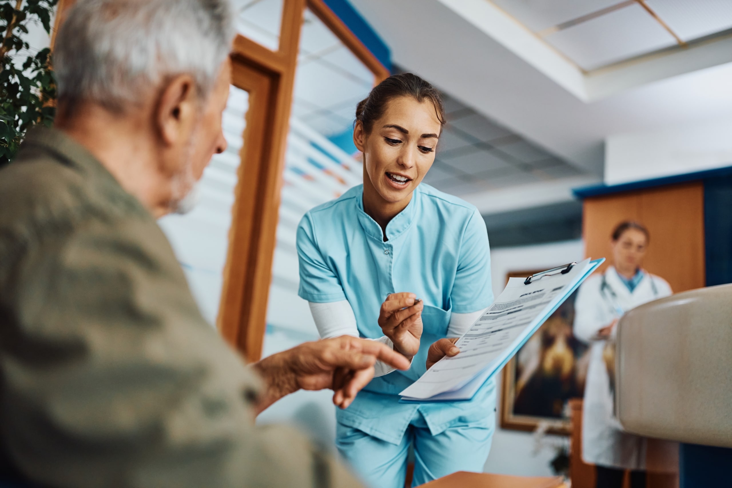 Young nurse helping an elderly man with paperwork