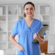 Smiling medical professional with a clipboard in scrubs