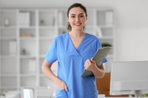 Smiling medical professional with a clipboard in scrubs