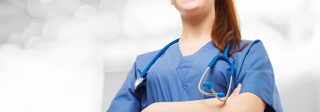 Smiling nurse in scrubs looking forward