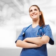 Smiling nurse in scrubs looking forward