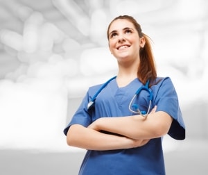 Smiling nurse in scrubs looking forward