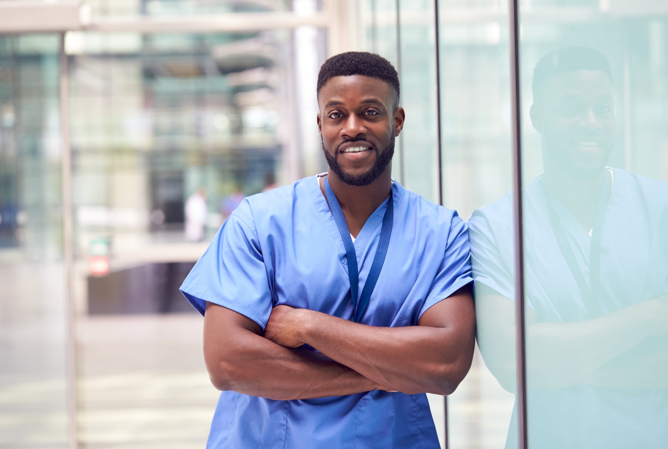 Male African-American nurse leaning against a building