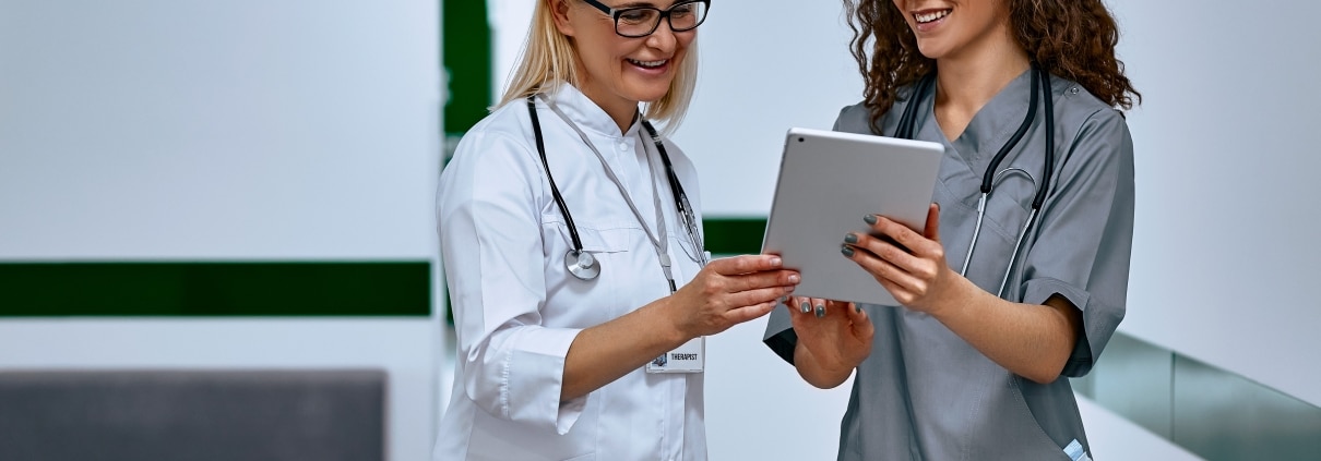 Female nurse and doctor discussing paperwork in a hallway