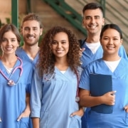 Group of smiling medical professionals in an outside hallway