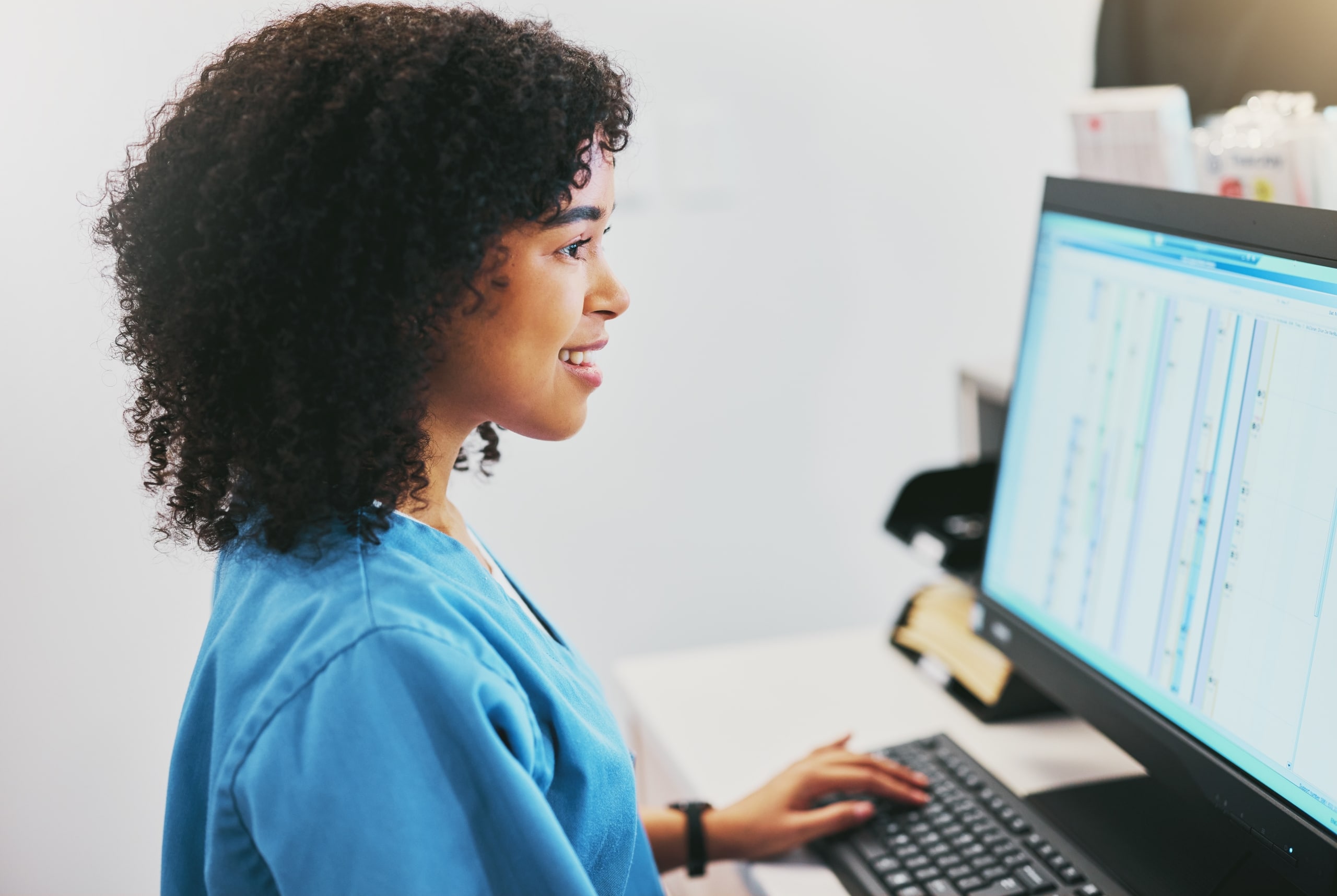 Female African-American nurse smiling on the computer
