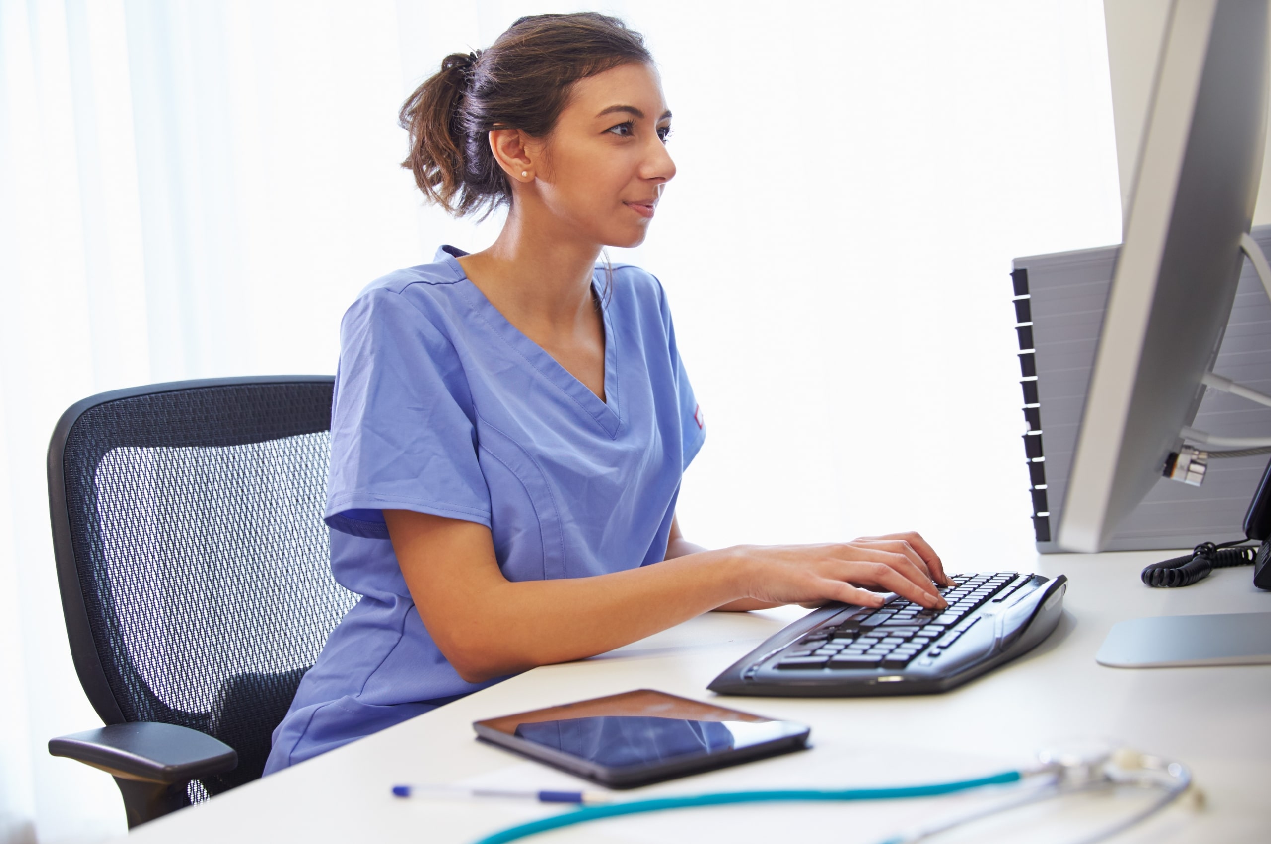 Young female nurse typing on a computer