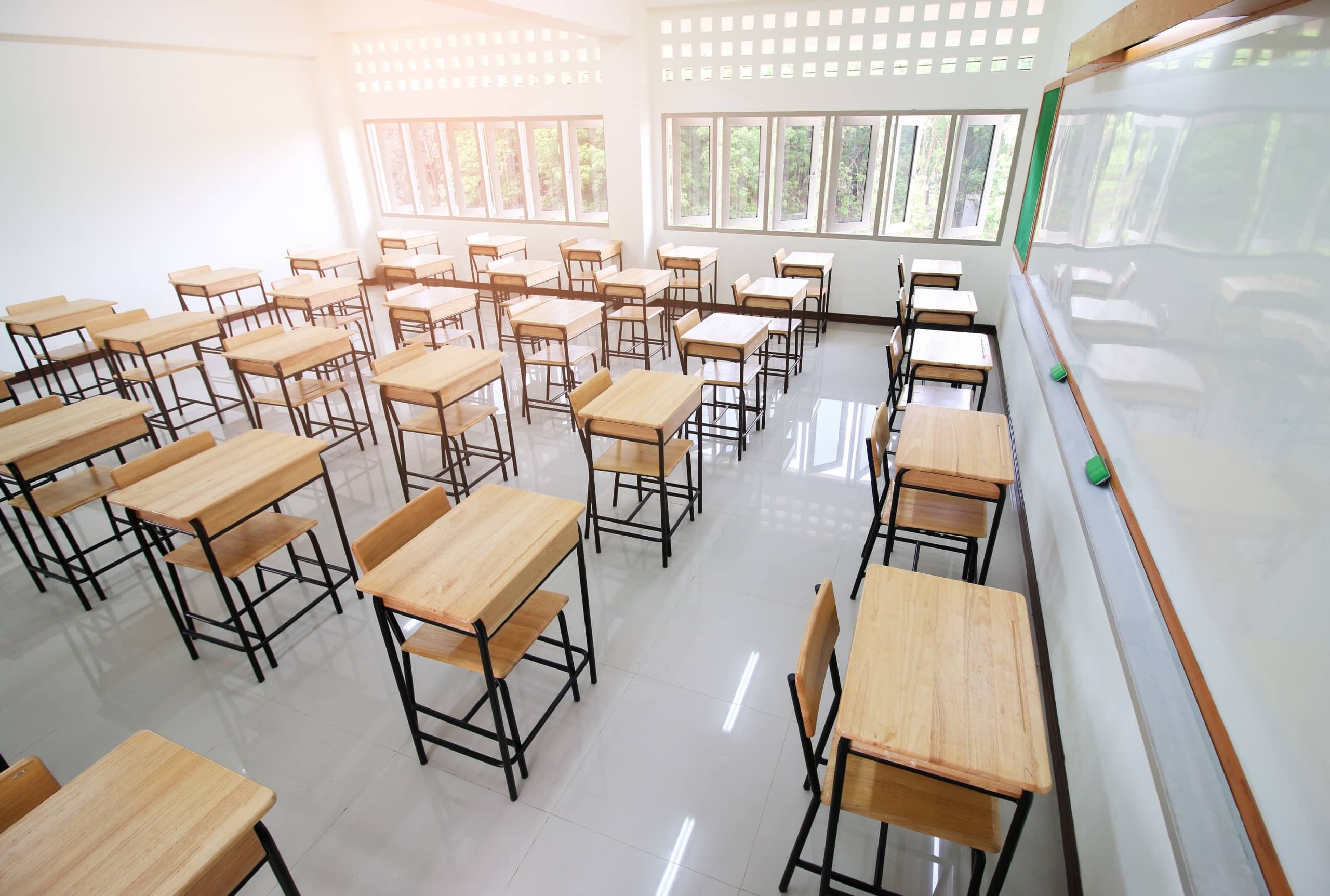 Overhead view of a sunny classroom with empty desks