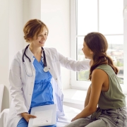 Smiling school nurse consoling a female student