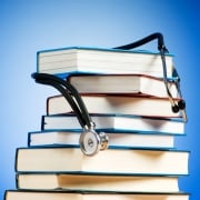 Stack of books with a stethoscope draped on top