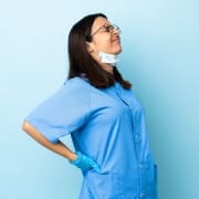 Nurse with glasses touching her back in pain
