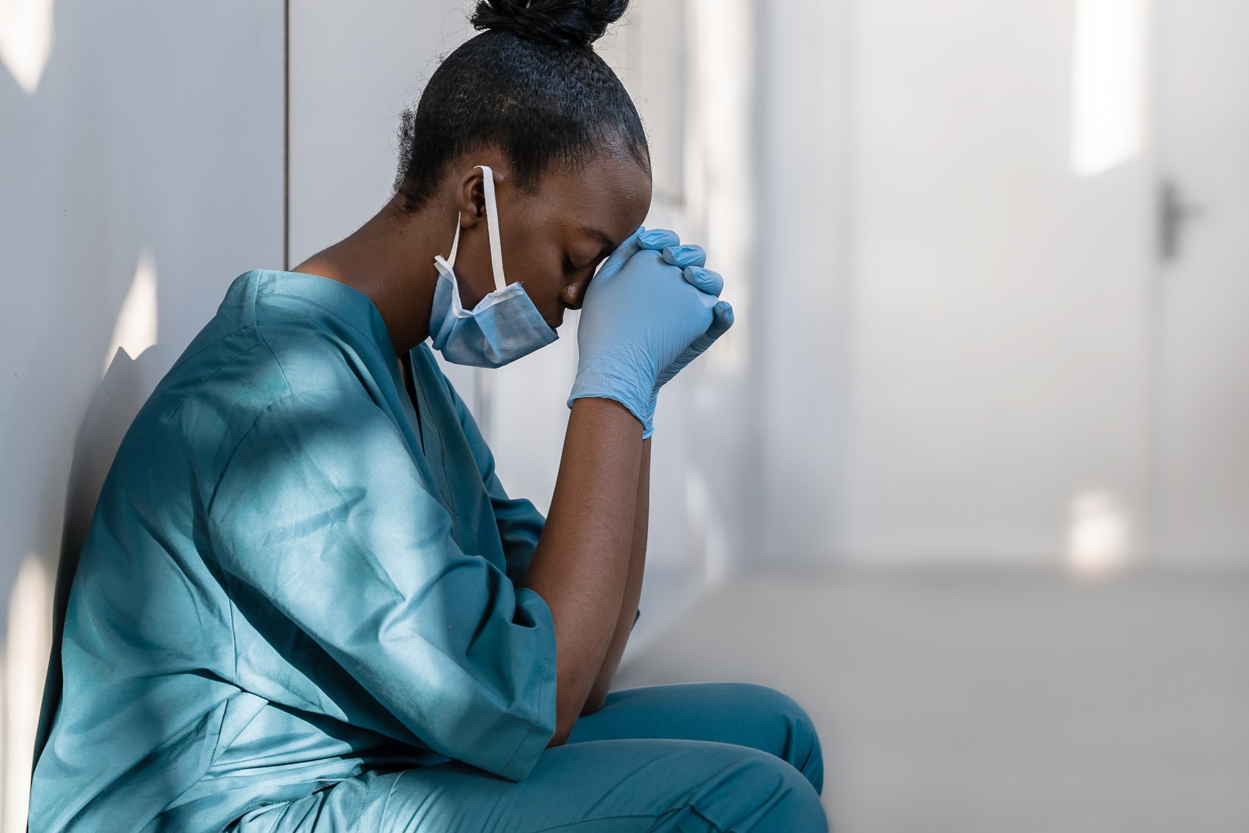 Exhausted nurse resting her head on her hands