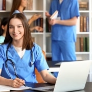 Nursing student using a laptop in a school library