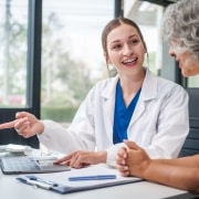 Caucasian medical professional speaking with an older patient