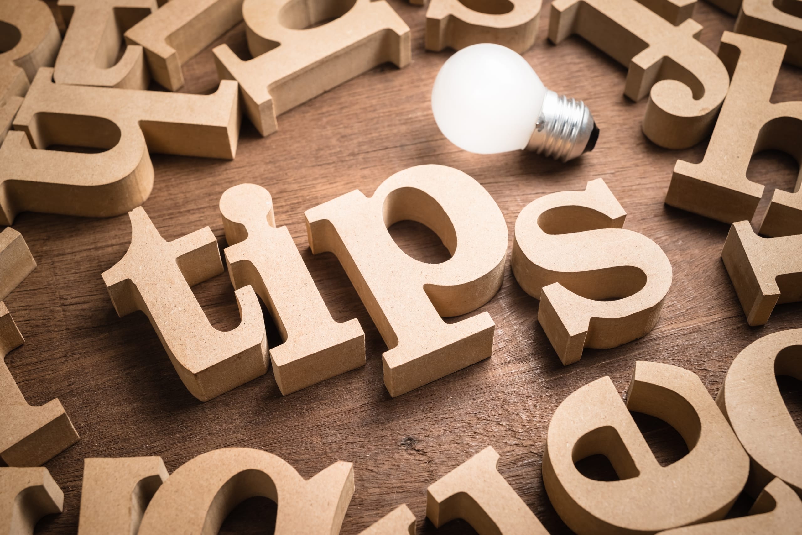 The word tips spelled with scattered wooden letters