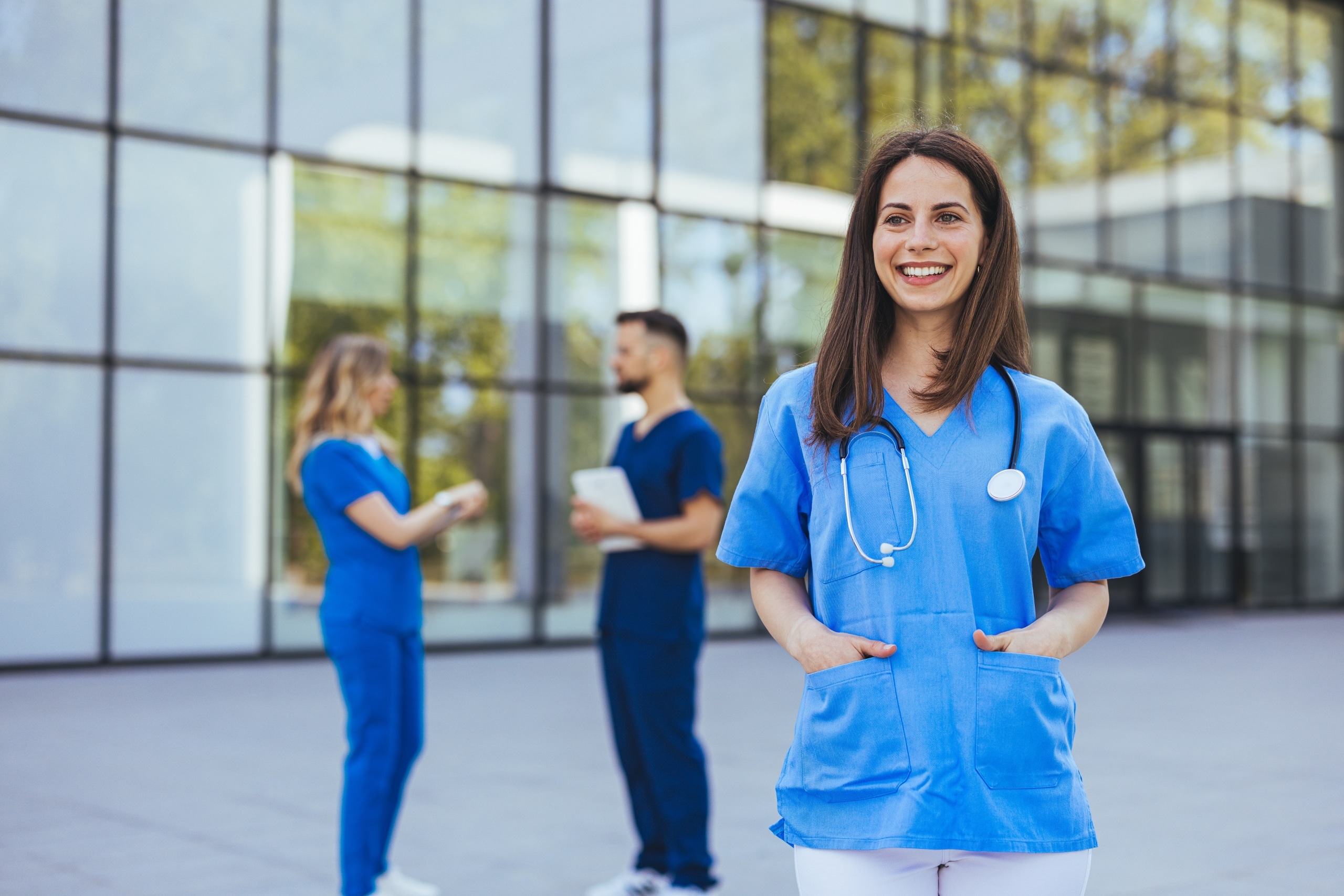 Smiling nurse standing outside in front of a hospital
