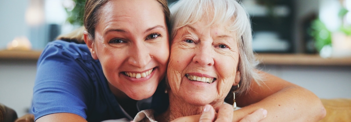 Happy medical professional hugging an elderly woman