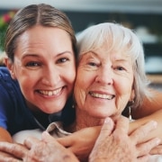 Happy medical professional hugging an elderly woman