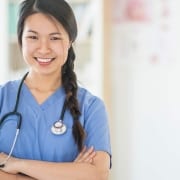 Asian nurse smiling with her arms crossed