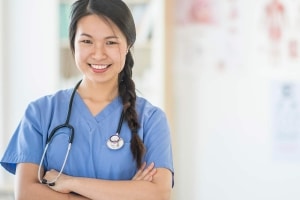 Asian nurse smiling with her arms crossed